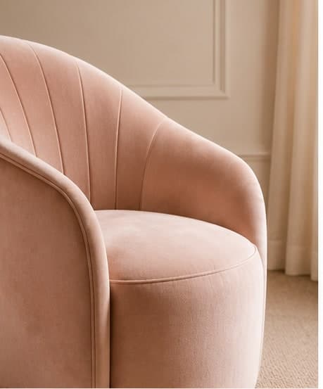 A pink velvet armchair — the curation, tactile.